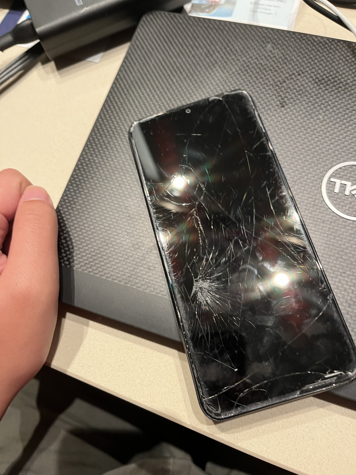 Original model input: a real smartphone with extensive visible cracking on its front surface